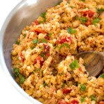 Mexican Cauliflower Rice in a metal skillet with a wooden spoon | chefsavvy.com