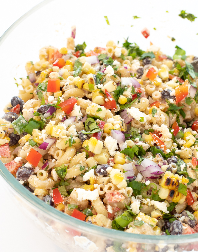 Mexican Street Corn Pasta Salad in a clear mixing bowl.