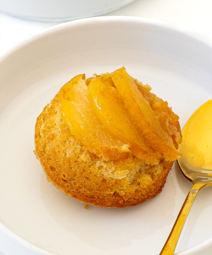 Apple upside down cake served on a plate with a golden spoon.