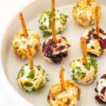 Mini Cheese Balls with pretzels on a white plate.