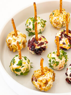 Mini Cheese Balls with pretzels on a white plate.