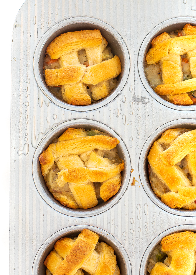 Pot pies after being baked, sitting in a greased muffin tin. 