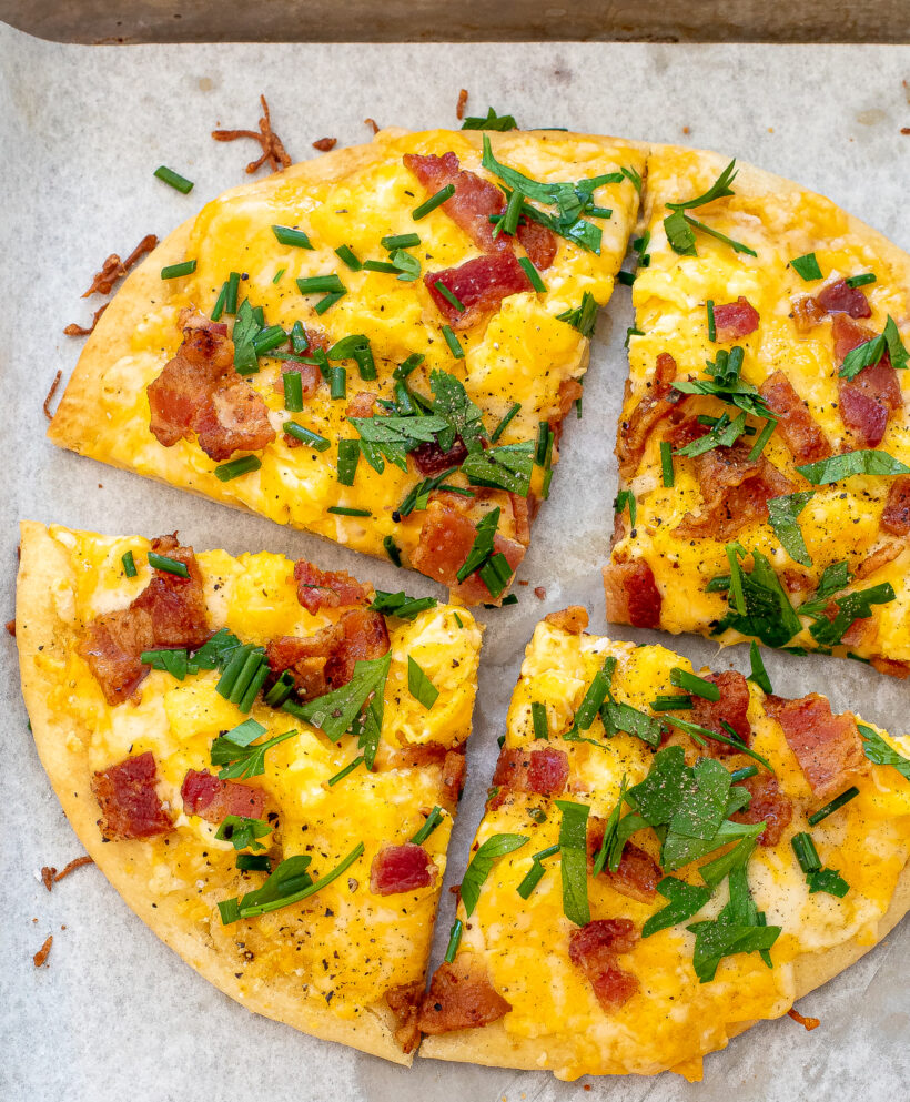 Breakfast pizza with eggs, cheese, bacon and herbs. 