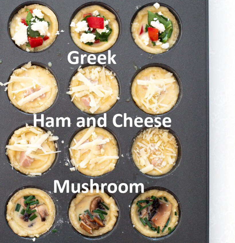 Mini quiche assembled in a mini muffin tin before baking with labels for different toppings.