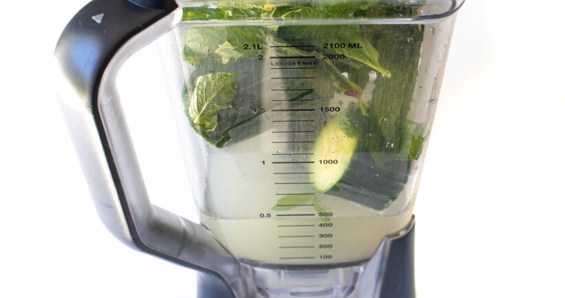 Side view of ingredients needed for mint cucumber lemonade in a blender.