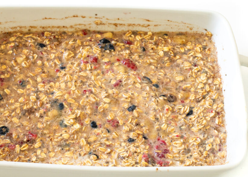 Berry baked oatmeal mixture in a baking dish before being baked.