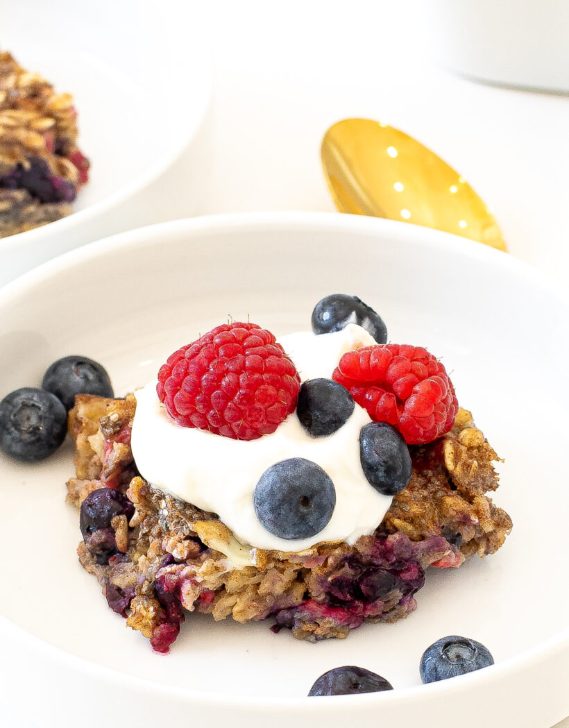 Portion of baked oatmeal with berries and yogurt on top.