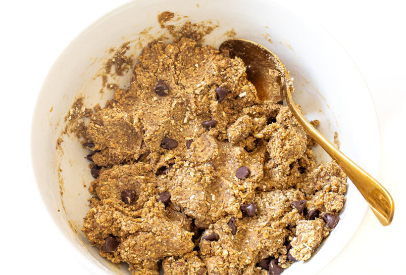 Protein bar oat mixture in a mixing bowl with a spoon. 