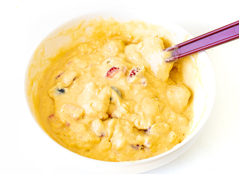 Muffin batter in a bowl with a rubber spatula.
