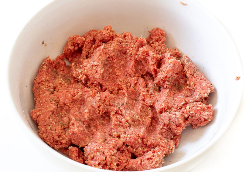 mixing ground beef meatball mixture in a large bowl