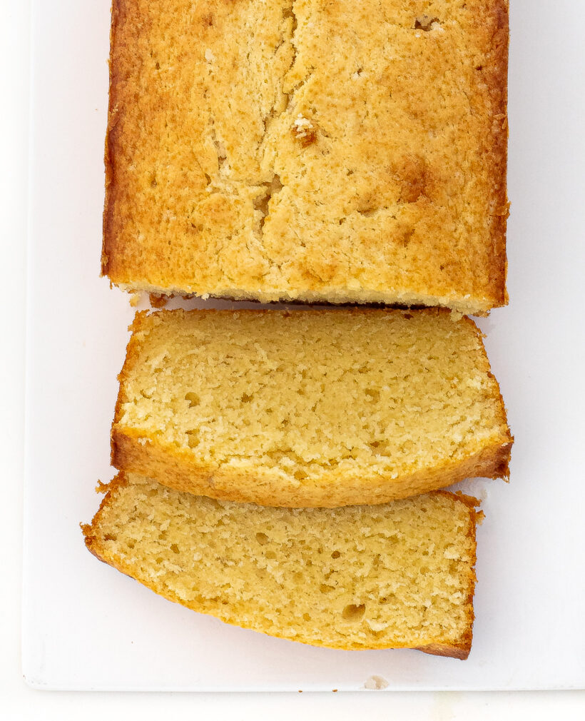 Sour cream pound cake loaf with a few pieces sliced off. 