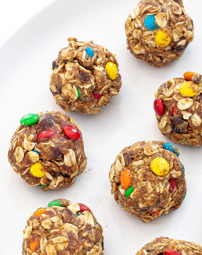 Energy balls with M&Ms lined up on a plate.