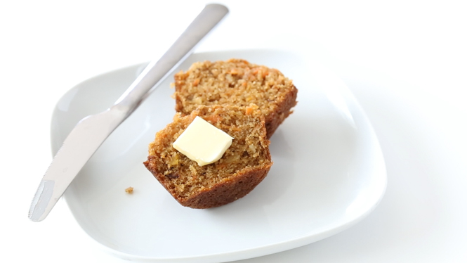 Healthy Carrot Cake Muffins served on a white plate with butter and a butter knife