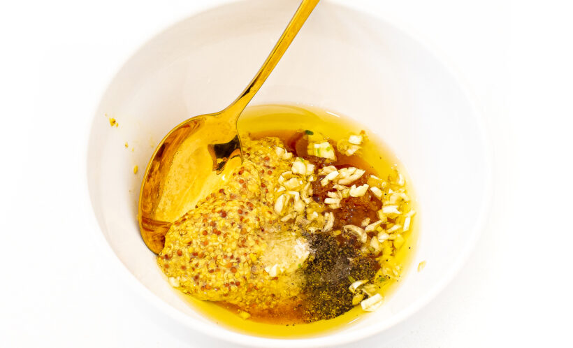 Ingredients for honey mustard sauce in a small bowl with a spoon. 