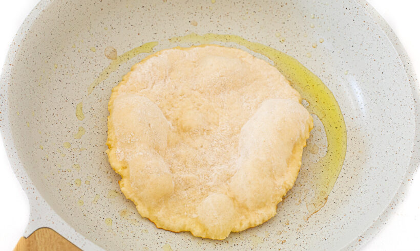 Naan dough on a hot skillet.