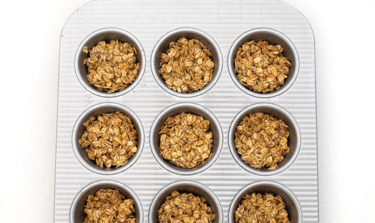Oat layer divided into a muffin tin.