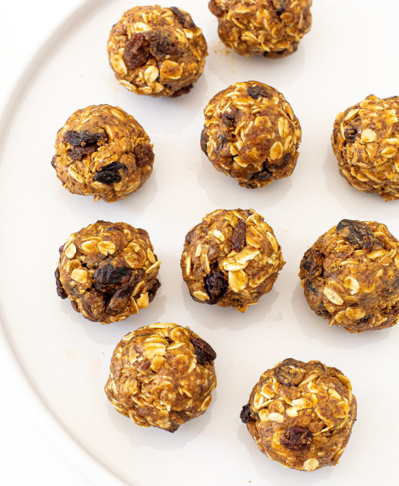 Overhead shot of oatmeal raisin energy bites lined up on a white plate. 