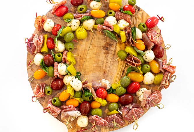 Antipasto on skewers in the shape of a circle on a wooden surface. 