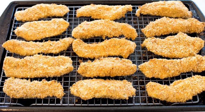 Baked chicken tenders on silver baking sheet with wire rack