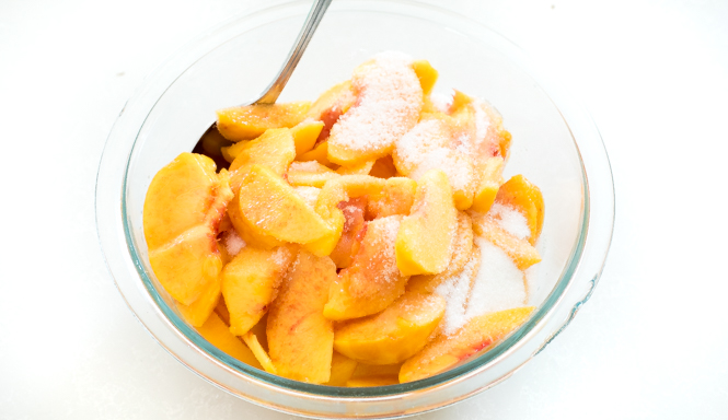 Peaches and sugar in bowl