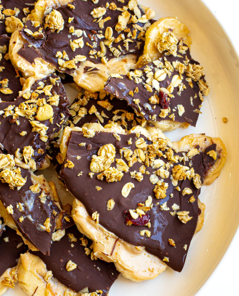 Frozen chocolate banana bark pieces on a plate. 