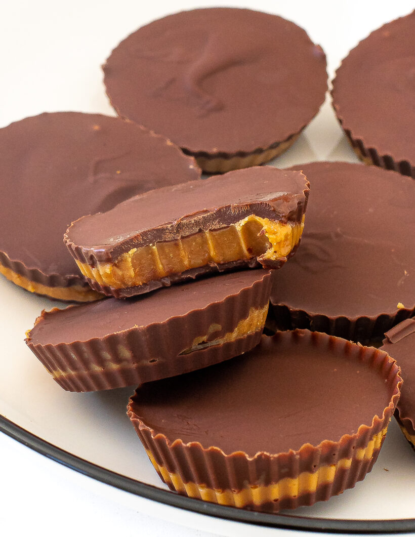 5 ingredient peanut butter cups served on a plate with one cup missing a bite.