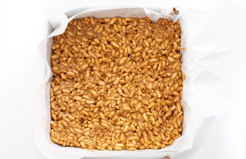Rice and peanut butter mixture in an even layer in a baking dish. 