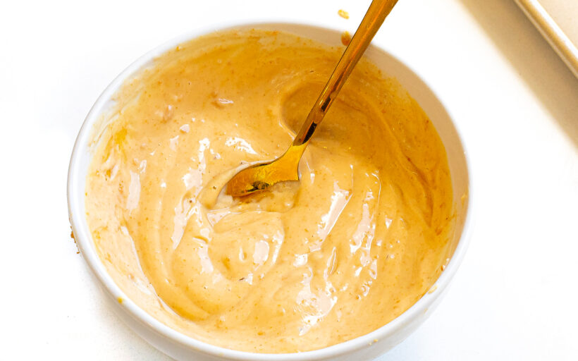 Peanut butter and yogurt being mixed in a bowl. 