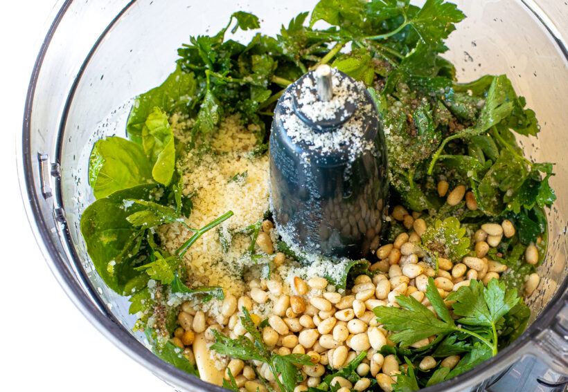 Pesto ingredients in a food processor.