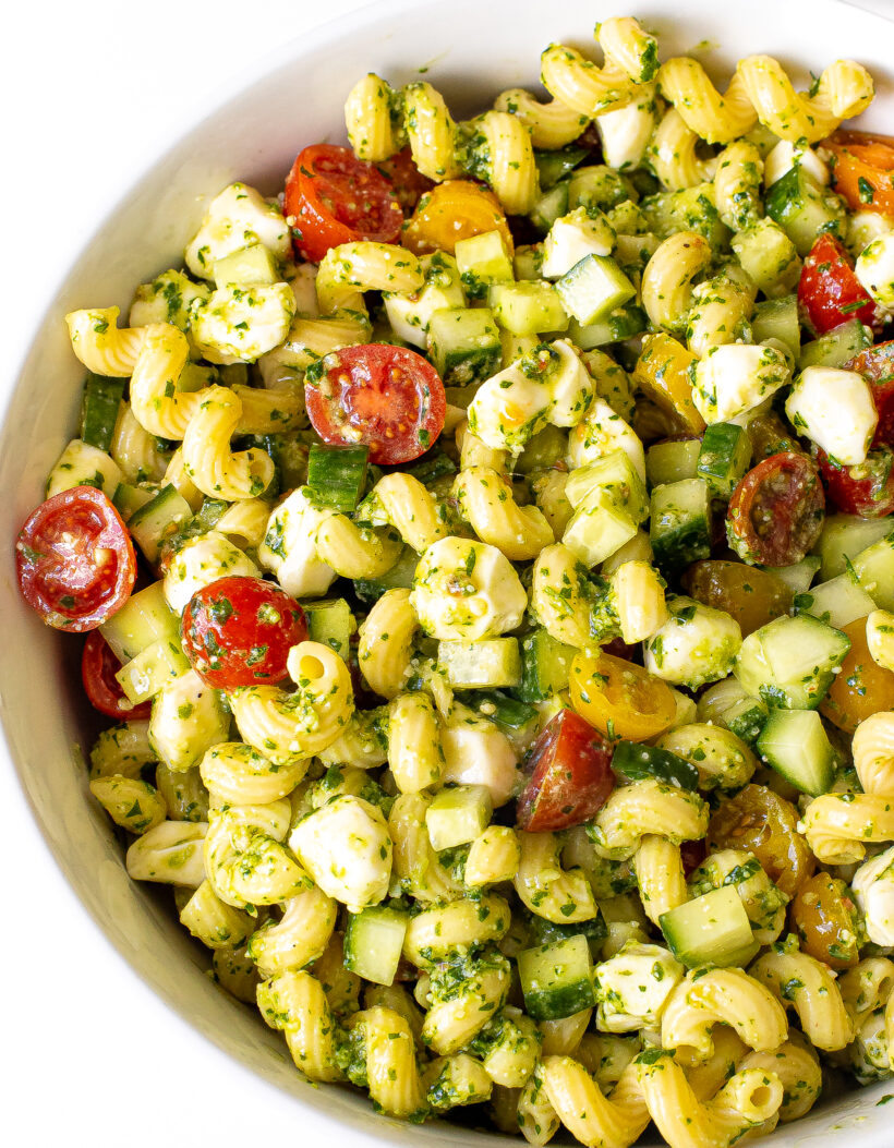Pesto pasta salad in white serving bowl.