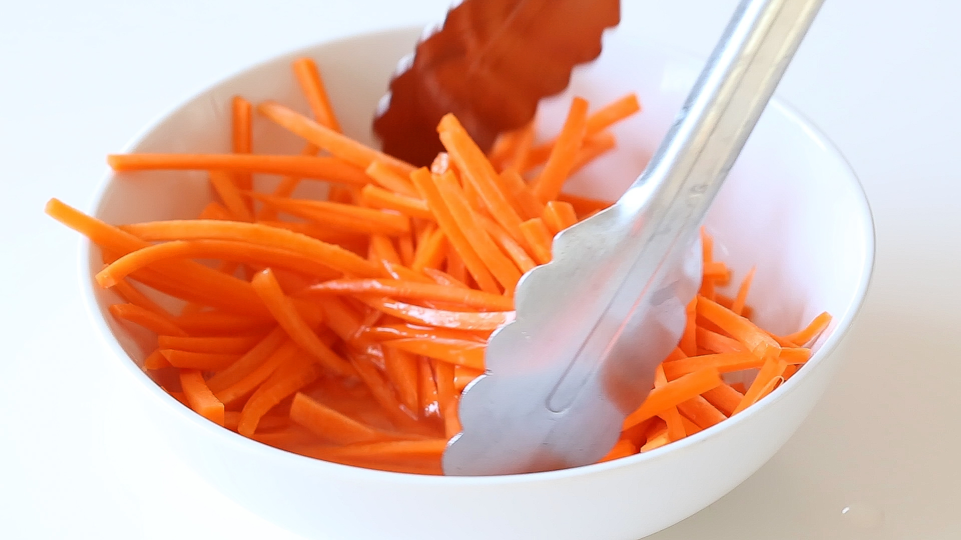 tossing carrots in rice wine vinegar and sugar