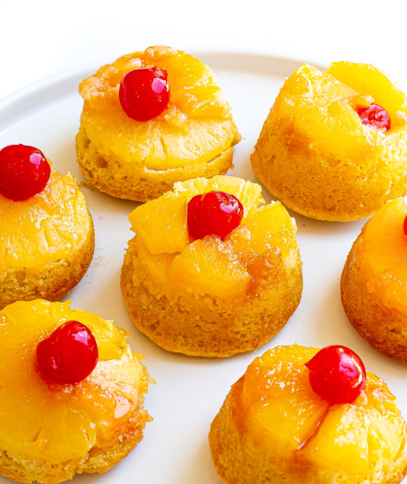 Mini pineapple upside down cakes served on a plate.