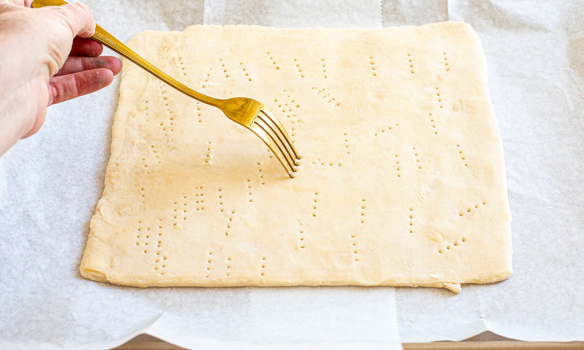 pricking unbaked puff pastry with fork