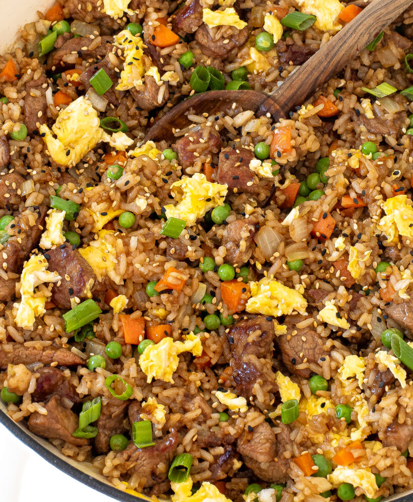 Pork fried rice in a skillet with sesame seeds on top.