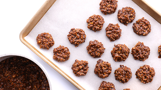 portioning no bake chocolate cookies onto a parchment lined baking sheet
