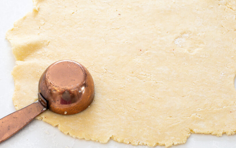 portioning pie dough into small rounds using a measuring cup