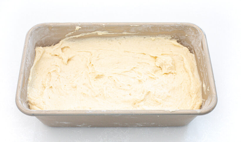 Loaf pan with pound cake batter in it before baking. 