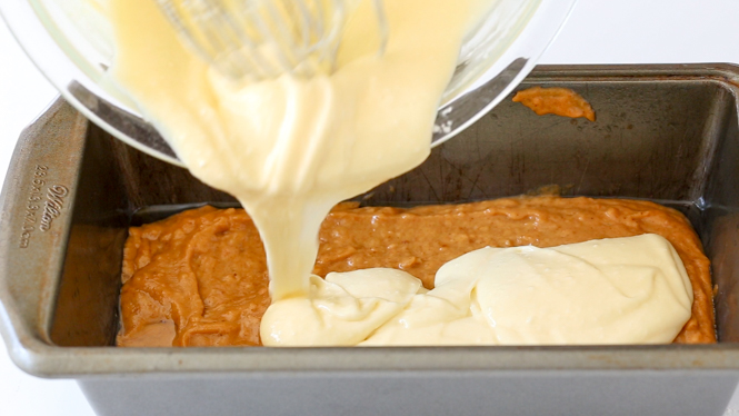 pouring cream cheese mixture on top of pumpkin bread batter