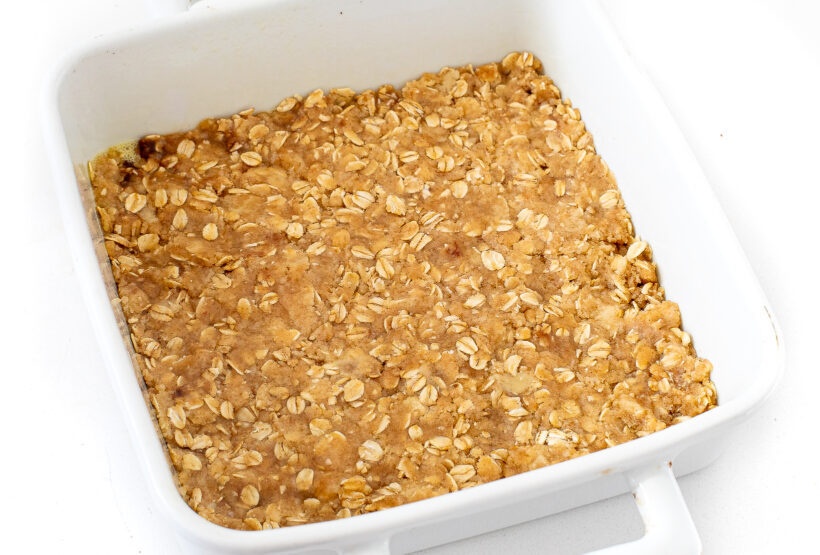 The crust pressed into a white baking dish.