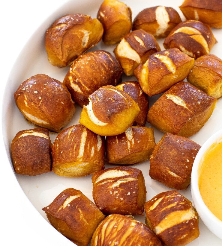 pretzel bites on white plate with cheese sauce