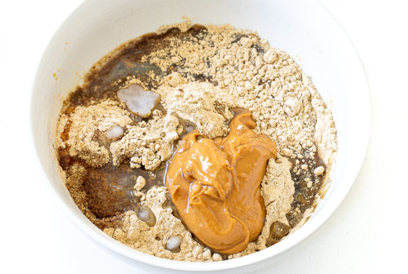 Ingredients for homemade protein bars in a bowl before being mixed.
