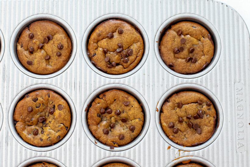 Pumpkin muffins in a muffin tin after being baked.
