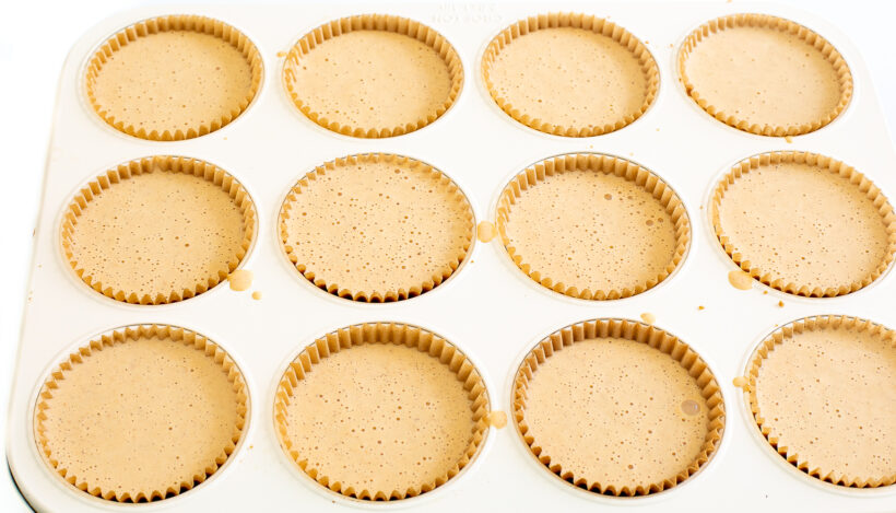 Unbaked cheesecakes in a muffin tin.