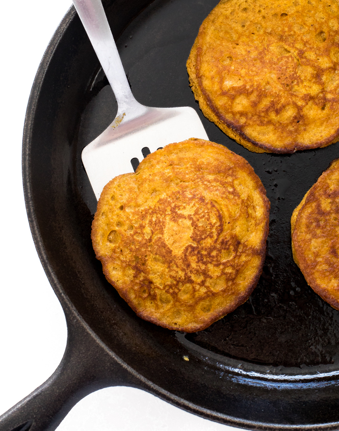 Pumpkin Pie Spice Pancakes | chefsavvy.com flipping pumpkin spice pancakes on cast iron skillet