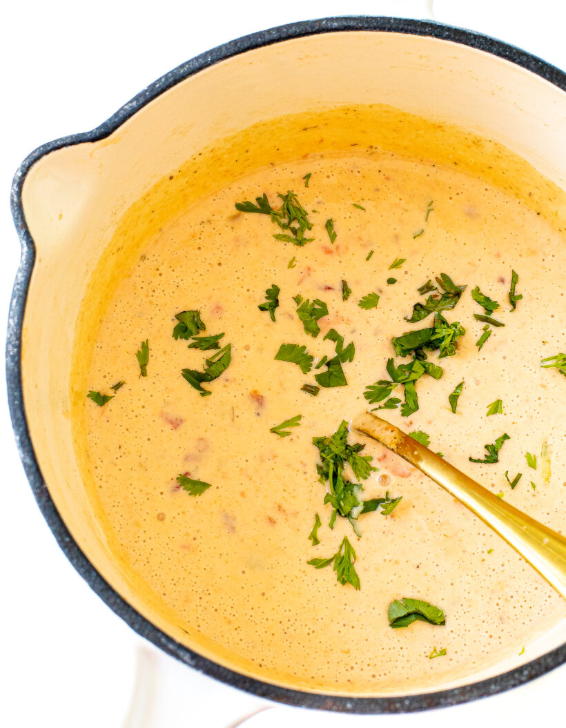 Queso topped with cilantro in a saucepan.