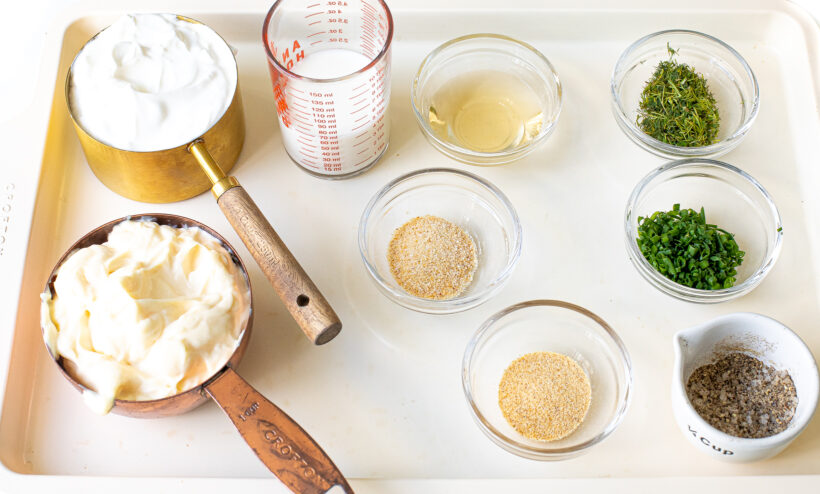 Ranch dressing ingredients laid out on a baking sheet.