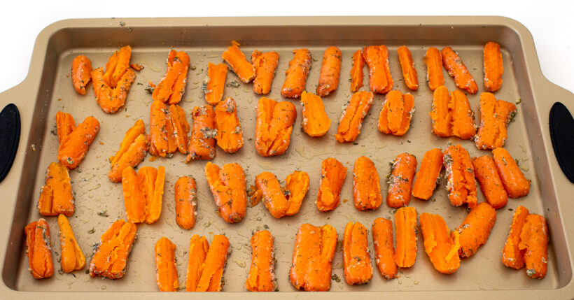 Carrots smashed on a baking sheet.