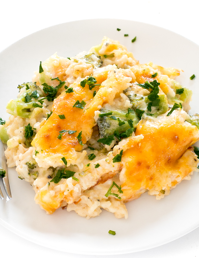serving of broccoli rice casserole on white plate topped with chopped parsley