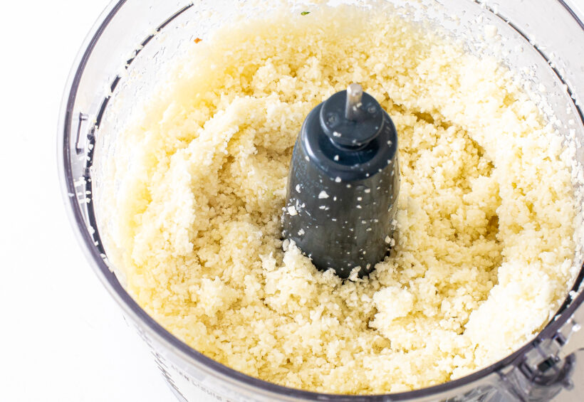 Cauliflower being riced in a food processor.