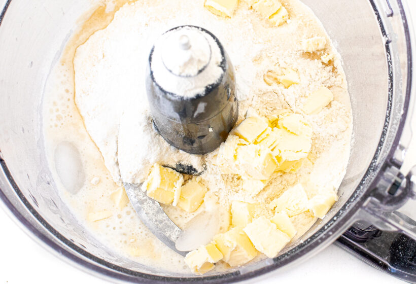 Top down view of a food processor bowl with Ritz crackers ingredients.